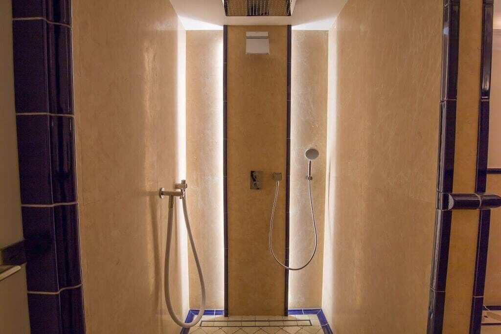 Un bagno con doccia, pareti piastrellate e una porta.