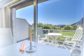 Un balcon avec une table, des chaises et une bougie.