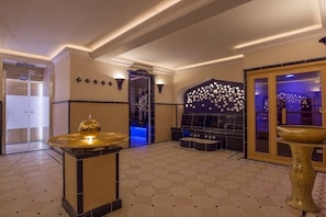 A lobby with a checkered floor, a central seating area with a sofa and ottoman, a decorative wall with a star pattern, and a large golden bowl. - Holiday apartment in Sylt with 1 bedroom (Wenningstedt)