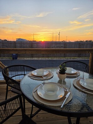 A table set for dining with a view of the sunset over a body of water. - NEW Charming Cottage in Rockport, Sunset Views, Dog-friendly - Sleeps 6 (Rockport)