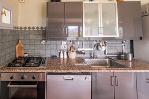 A kitchen with granite countertops, stainless steel appliances, and a dishwasher. - Holiday home with 2 bedrooms (Caseneuve)