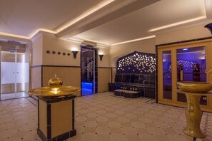 Eine großzügige Lobby mit einer zentralen Sitzecke, einer Wandverkleidung und einem großen Fenster.