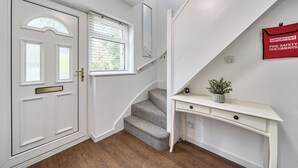 En trappe fører op til en platform med et hvidt konsolbord og en rød branddokumentholder.