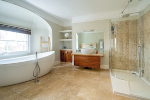 A modern bathroom with a freestanding bathtub, a glass-enclosed shower, and a vanity with a sink and mirror. - Elegant Georgian townhouse to sleep 8, town centre - Pass the Keys (Shrewsbury)