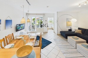 Ein modernes Wohnzimmer mit einer Couch, einem Couchtisch und einem Essbereich.