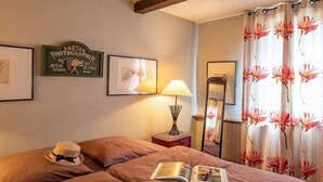 Une chambre d’hôtel avec un lit, une lampe, un panneau encadré et un miroir.