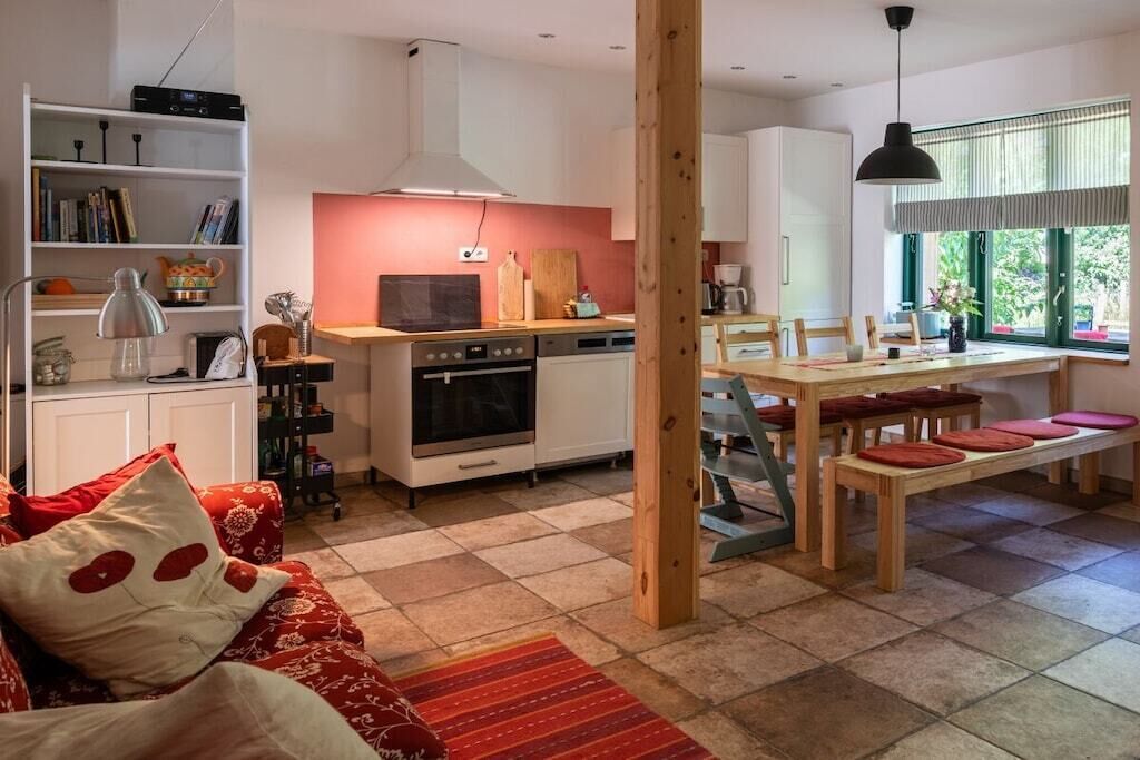 A compact living space with a kitchenette, dining area, and a bookshelf.