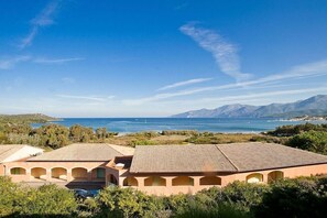 A coastal property with multiple buildings, a clear view of the sea, and distant mountains. - Holiday apartment with 1 bedroom (Saint-Florent)