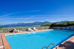 En swimmingpool med utsikt över bergen och havet.