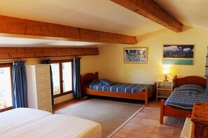 Ein Zimmer mit zwei Einzelbetten, einem Kleiderschrank und einem Fenster mit Vorhängen.