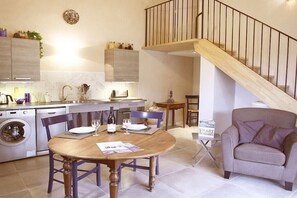 A modern kitchen with a dining area, a sofa, and a staircase. - Holiday apartment in Apt with swimming pool (Apt)