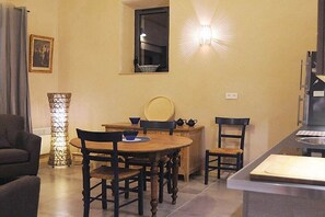 A dining area with a round table, chairs, a small window, and a light fixture. - Holiday apartment in Apt with swimming pool (Apt)