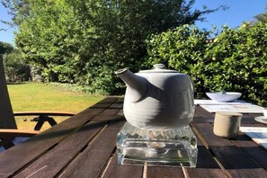 A clear glass teapot on a wooden table outdoors. - Holiday home with 2 bedrooms (Retranchement)