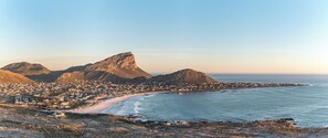 Un pueblo costero con una montaña destacada, una playa y vista al océano.
