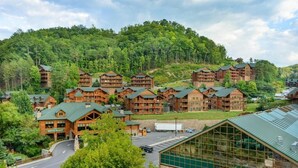 A lodge with multiple wooden buildings, a restaurant, and a large glass structure. - Spend Christmas week in a beautiful Smoky Mountain resort with onsite waterpark! (Gatlinburg)