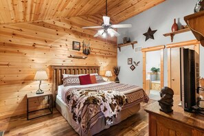 A wooden cabin bedroom with a bed, nightstands, a ceiling fan, and a dresser. - Branson Woods Luxury Cabins - 8 Bedrooms- Lots of Cabins for Reunions, 3 Pools, Every Resort Amenity (Branson)