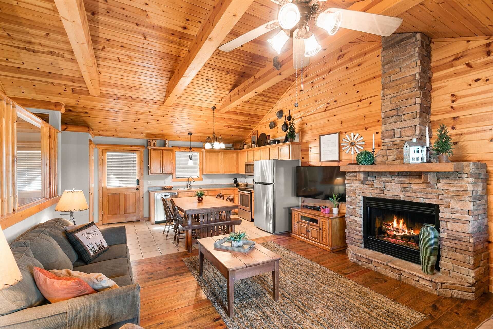 A cozy cabin interior with a dining area, kitchen, and living room.