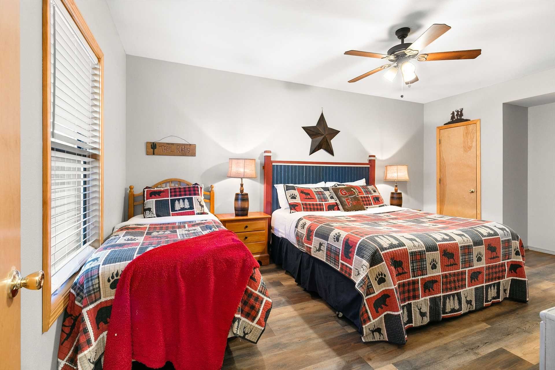 A bedroom with two beds, a ceiling fan, a star decoration, and a sign that reads 'Trail Ridge.'