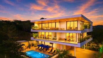 A modern multi-story building with a pool and outdoor seating.