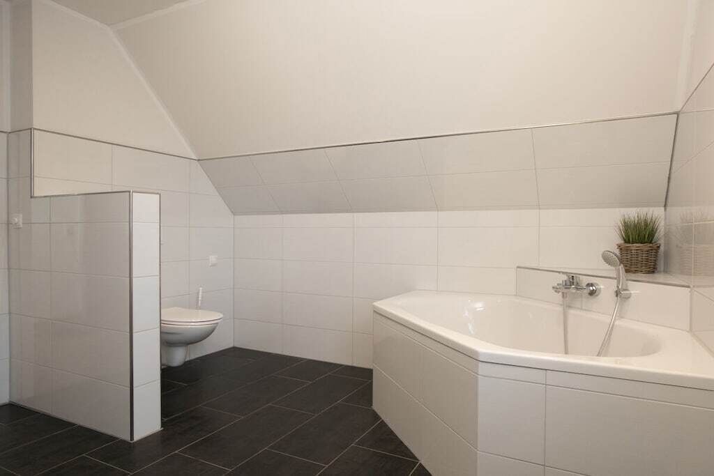Une salle de bain moderne avec une baignoire, des toilettes et un lavabo d’angle.
