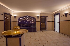 A spacious room with a patterned floor, a decorative wall with a floral design, and a golden spherical object on a table. - Holiday apartment in Sylt with 1 bedroom (Wenningstedt)