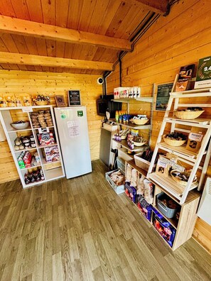 Un intérieur en bois, avec un réfrigérateur, des étagères remplies d’en-cas et un panneau indiquant une note de 9,4.