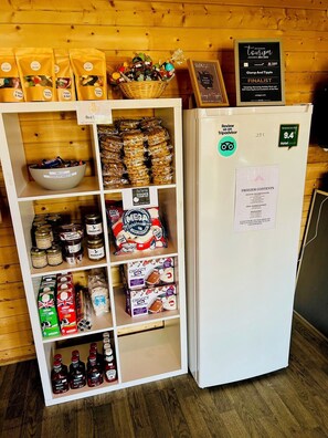 Un refrigerador de hotel lleno de diversos alimentos y un cartel que indica una calificación de 9.4 de TripAdvisor.