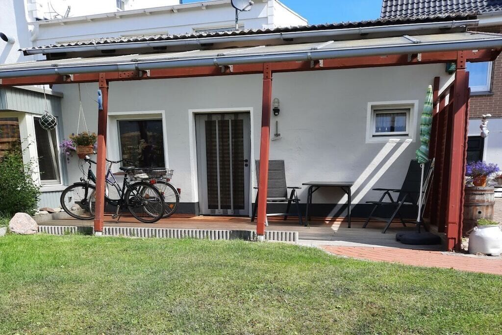 Un patio abrité avec un vélo, une table et des chaises.
