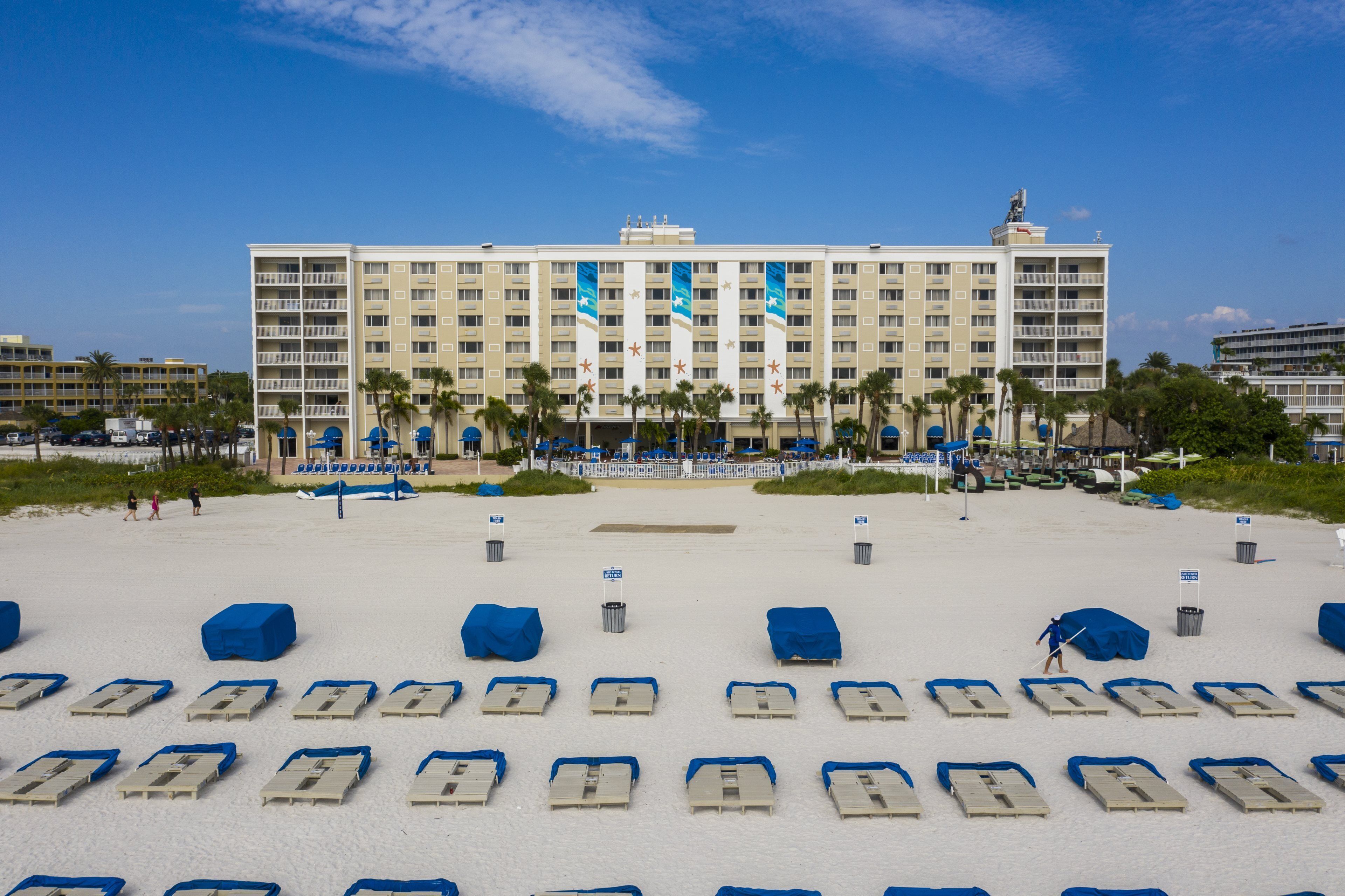 Ein Hotel mit Blick auf den Strand, mehreren Etagen und einem großen Gebäude mit Flaggen.