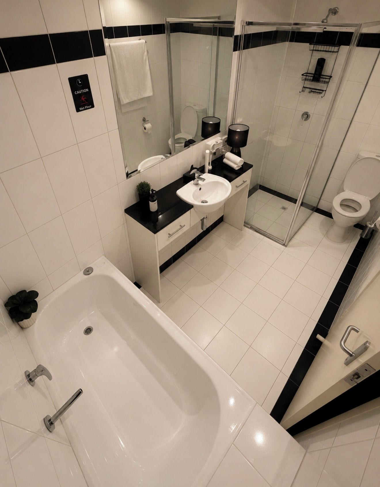 Un baño moderno con una bañera, lavamanos, cabina de ducha de vidrio y un inodoro.