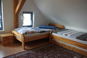 A room with two wooden bunk beds, a small wooden desk, and a patterned rug. - Holiday apartment in Clausdorf with barbecue (Clausdorf)