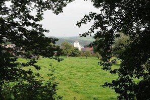 Ein grünes Feld mit einem Gebäude in der Ferne, umgeben von Bäumen.