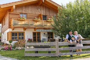 Een houten chalet met balkon, eethoek en tuin.