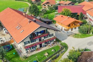 Ein Wohngebiet mit Häusern, die rote Ziegeldächer, einen Swimmingpool und einen gepflegten Rasen haben.