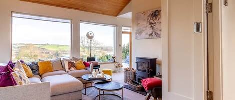 A modern living room with a sofa, coffee table, and fireplace.