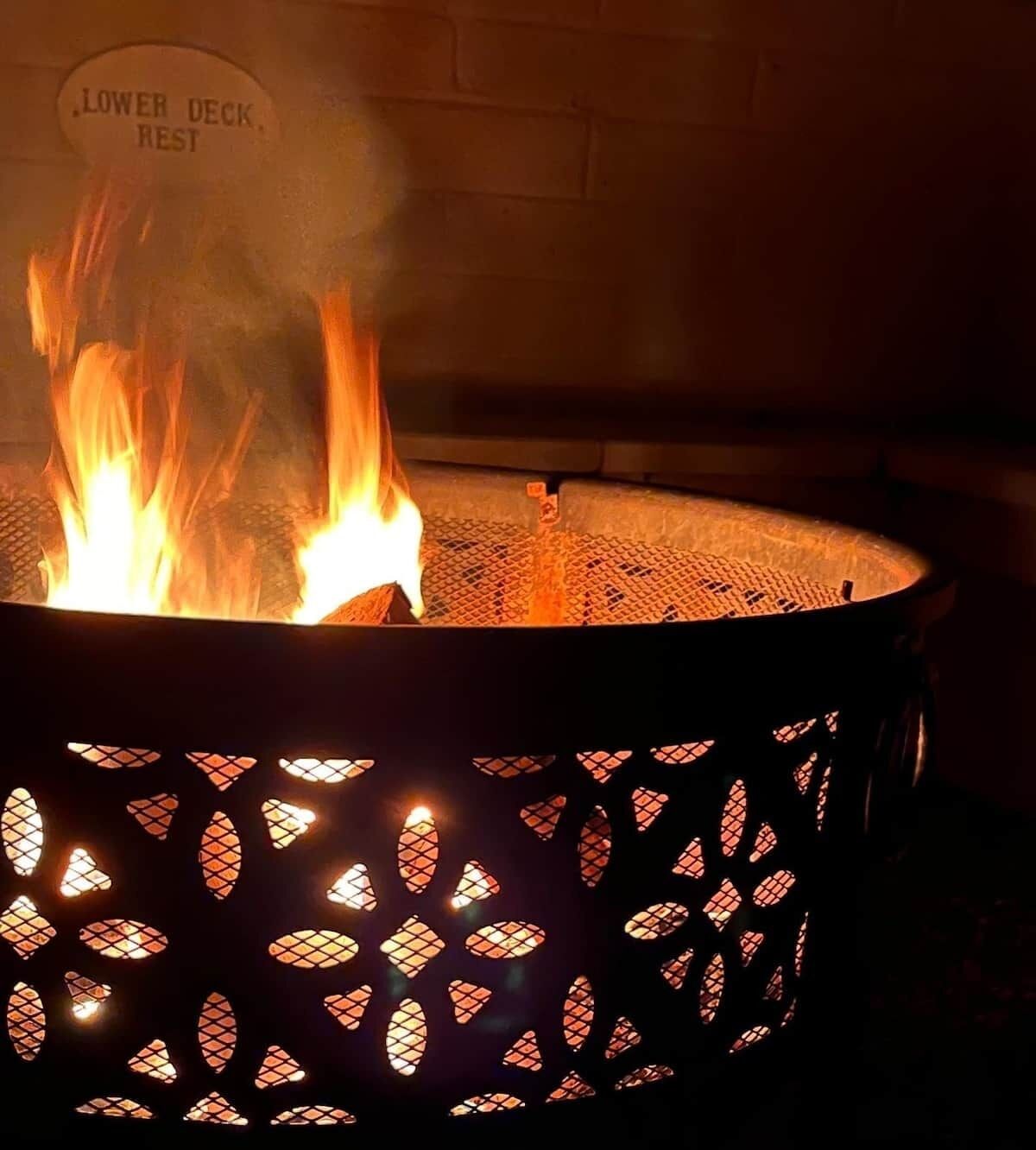 A fire pit with a sign indicating 'Lower Deck Rest' and a mesh cover.