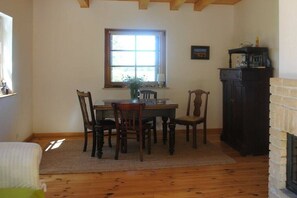 A dining area with a table and chairs, a window, a fireplace, and a cabinet. - Holiday home in Sasino with swimming pool (Sasino)