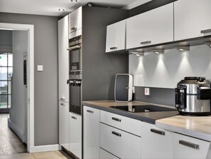 A modern kitchen with built-in appliances, grey cabinets, and a stainless steel coffee maker. - Stunning  villa for 8 people with WIFI and terrace (Ardrossan)