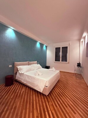 Een slaapkamer met een bed, een raam en een houten vloer.