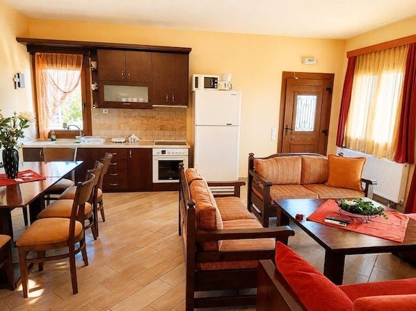 Un espacio habitable compacto con kitchenette, comedor y zona de estar.
