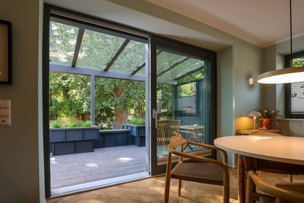 Ein modernes Interieur mit einer Schiebeglastür, die zu einer Außenpatiofläche führt.
