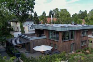 A modern building with a flat roof, large windows, and a covered outdoor seating area. - Holiday apartment in Wildeshausen with Wi-Fi (Wildeshausen)
