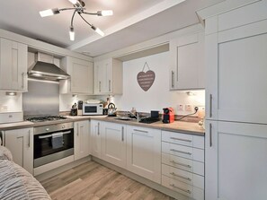 A modern kitchen with stainless steel appliances, white cabinetry, and a heart-shaped wall decoration. - Lovely apartment for 4 people with WIFI and TV (Alexandria)