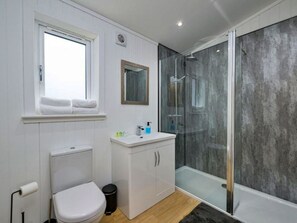 Een moderne badkamer met toilet, wastafel en douche.