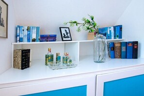 Ein Bücherregal mit Büchern, ein gerahmtes Bild und eine Vase mit Blumen.