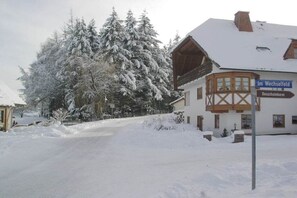 A snow-covered building with a sign reading 'Im Wechselseid' and a wooden structure with a balcony. - Holiday apartment with 1 bedroom (St. Peter)