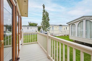 Ein Balkon mit Blick auf eine Baumwiese und Wohnmobile.