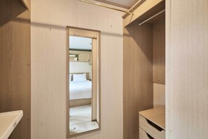 Ein Hotelzimmer mit Spiegel, Bett und einer kleinen Holzkombination.