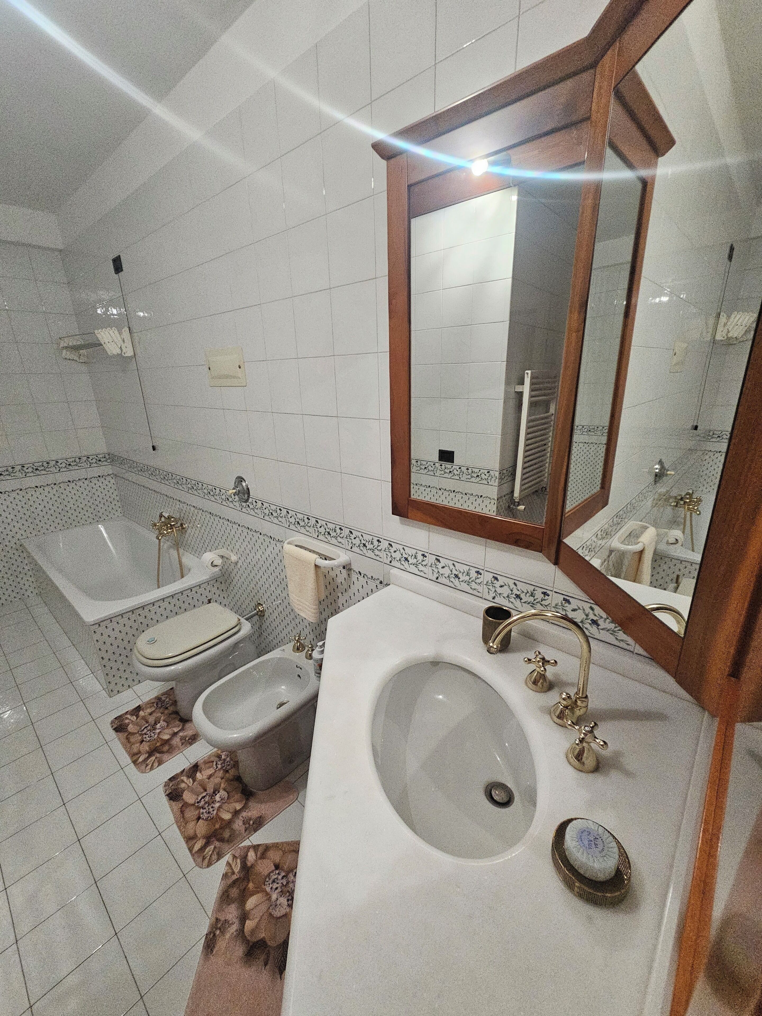 Une salle de bain équipée d’une baignoire, de toilettes, d’un bidet et d’un lavabo.