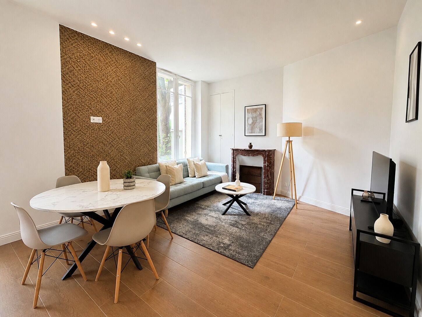 A modern living room with a dining area, a fireplace, and a television.